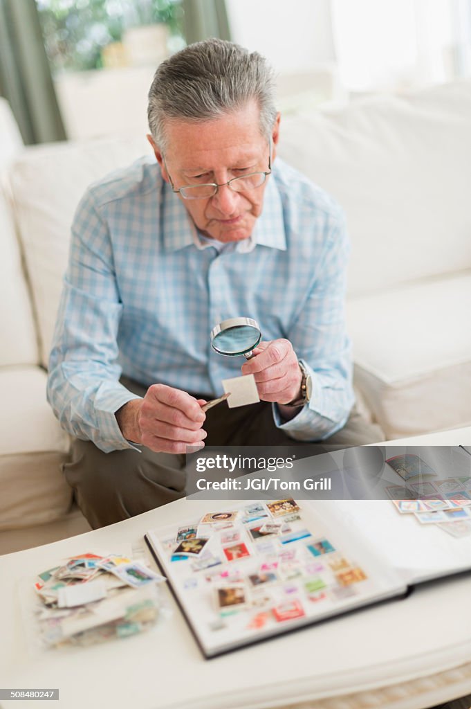 Senior Caucasian man examining stamp collection