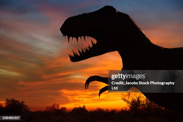 silhouette of dinosaur sculpture at sunset, moab, utah, usa - tyrannosaurus rex stockfoto's en -beelden
