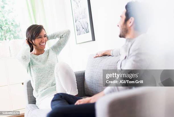 couple relaxing together on sofa - arab couple stock pictures, royalty-free photos & images