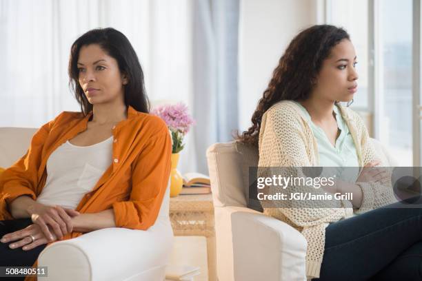 mother and daughter arguing in living room - angry woman stockfoto's en -beelden