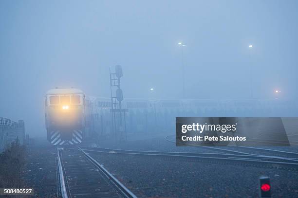 train light in foggy station - train yard at night stock pictures, royalty-free photos & images