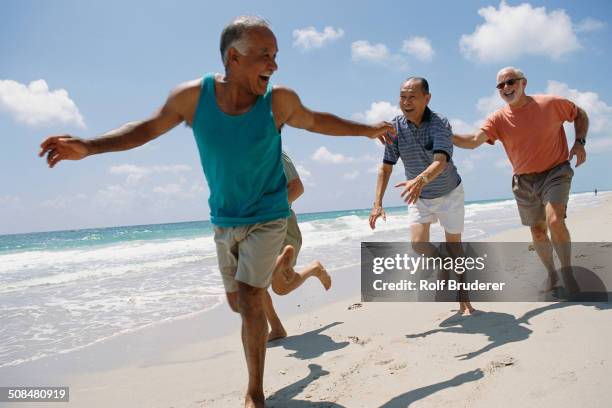 senior friends jogging on beach - ir em frente imagens e fotografias de stock