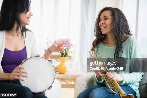 mother and daughter playing music together - instrument à percussion photos et images de collection