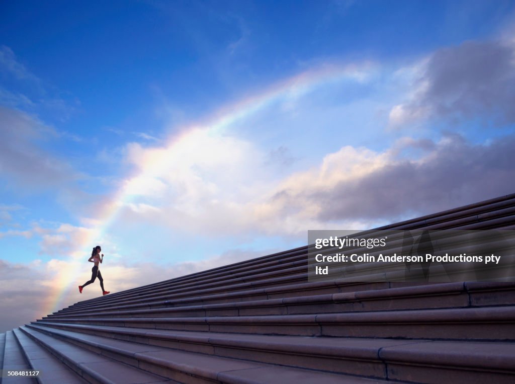 Pacific Islander woman jogging on concrete steps
