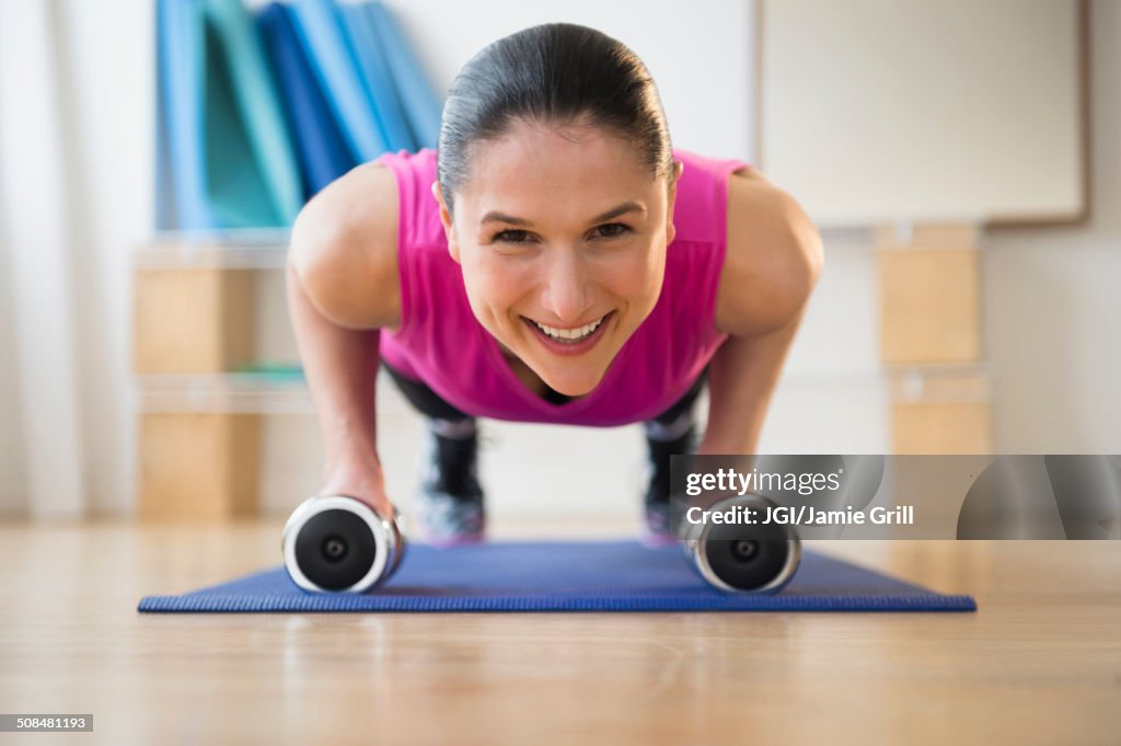 Caucasian woman doing push ups on yoga mat