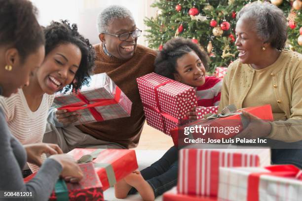 family opening christmas presents together - old man woman christmas stock pictures, royalty-free photos & images