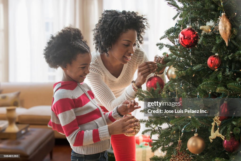 Mother and daughter decorating Christmas tree