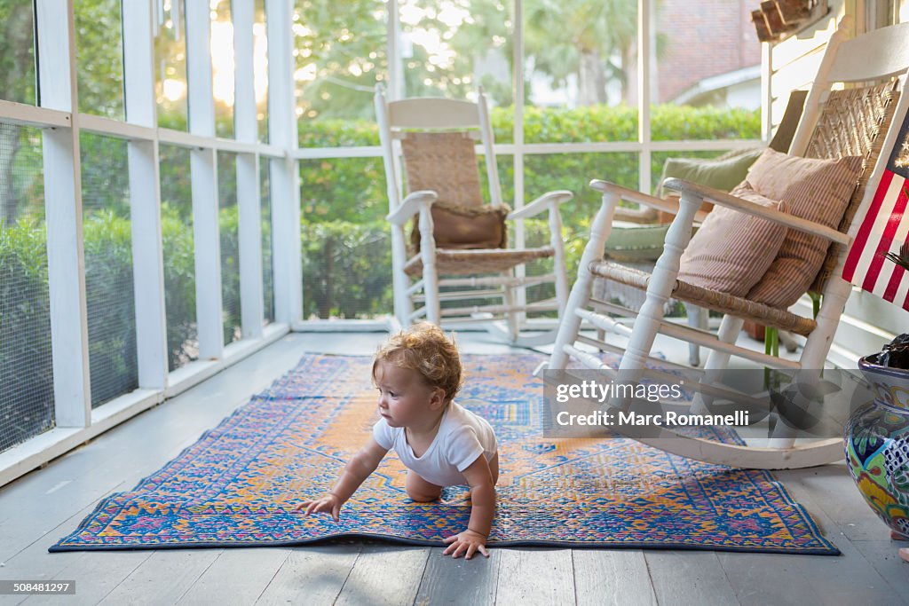 Caucasian baby crawling on porch