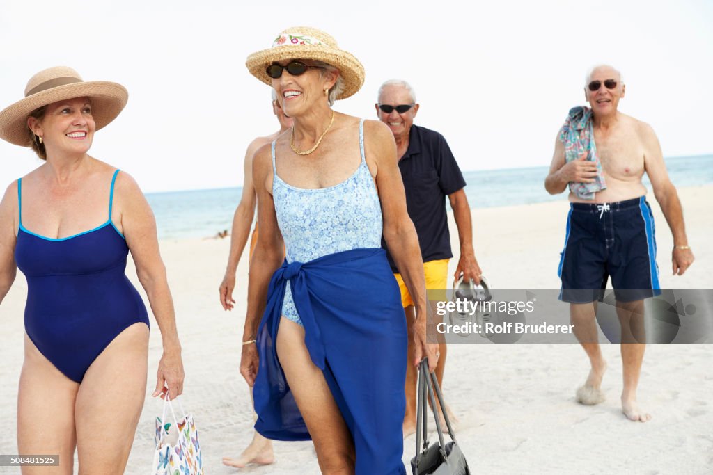 Senior friends walking on beach