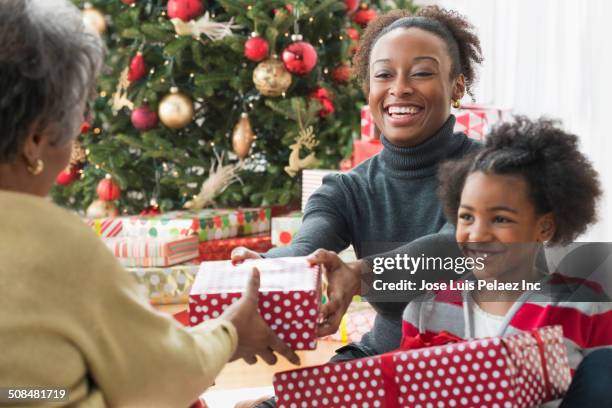 family opening christmas presents together - christmas gift exchange stock pictures, royalty-free photos & images