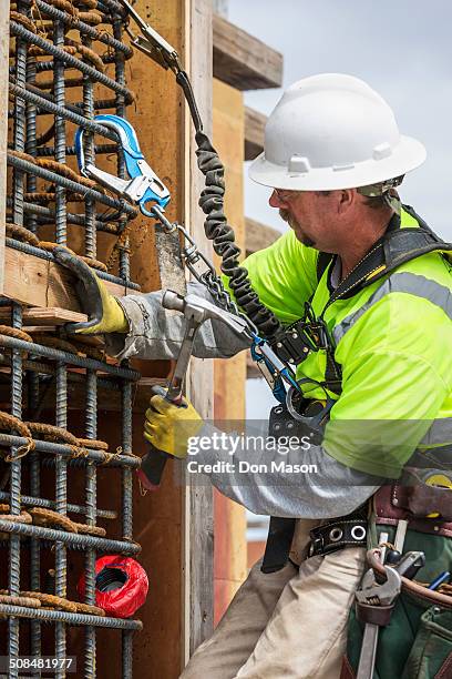 caucasian worker examining wall at construction site - safety equipment stock-fotos und bilder
