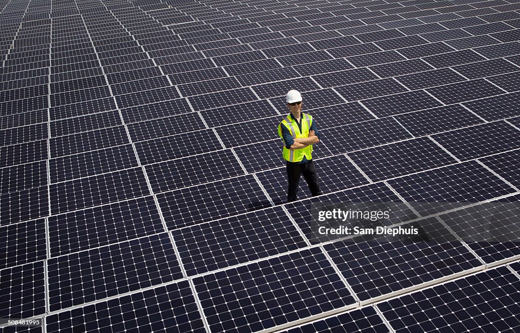 Caucasian technician smiling on solar panels