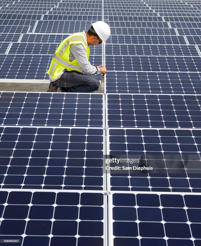 Asian technician working on solar panels