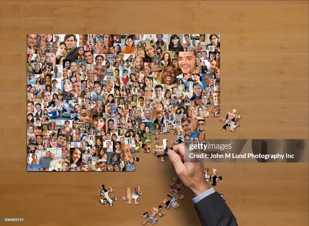 Businessman assembling puzzle of collage of smiling face