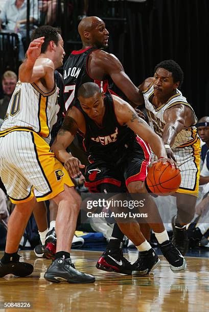 Caron Butler of the Miami Heat is covered by Jeff Foster of the Indiana Pacers as he drives around a pick set by Lamar Odom of the Heat against Ron...