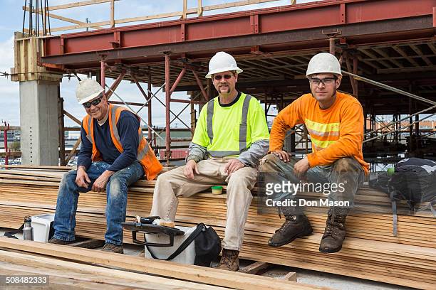 caucasian workers smiling at construction site - taking america to lunch stockfoto's en -beelden
