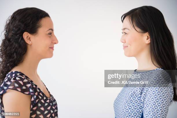 women smiling at each other - gezicht aan gezicht stockfoto's en -beelden