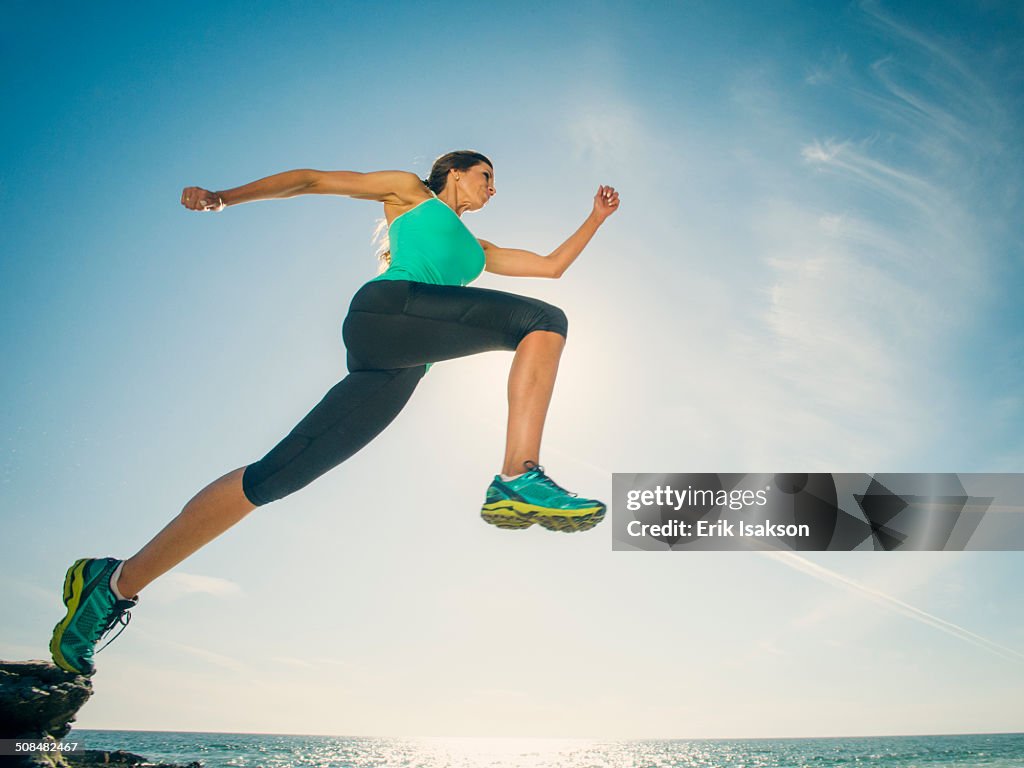 Caucasian woman running on beach