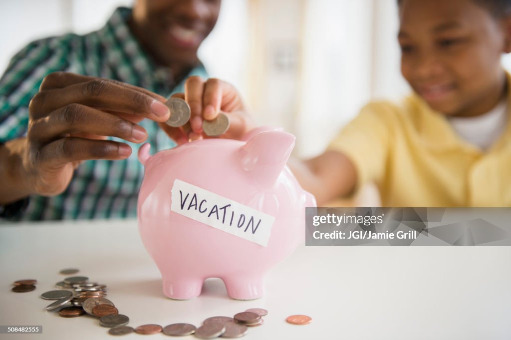 Father and son saving coins for vacation