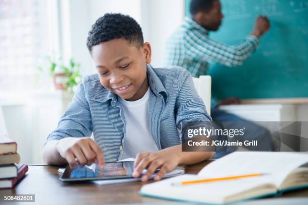 student using tablet computer in classroom - kids modern school life stock-fotos und bilder