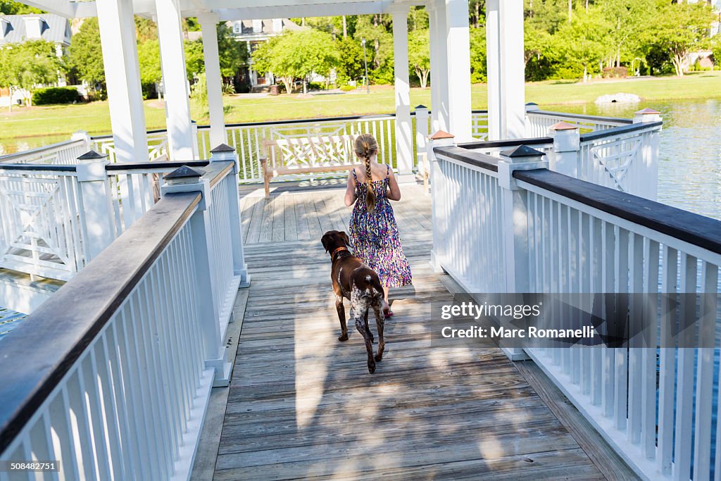 Caucasian girl walking with dog in gazebo