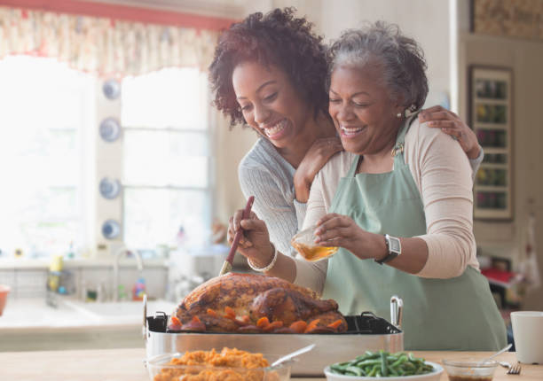 mother and daughter cooking together in kitchen - thanksgiving stock pictures, royalty-free photos & images