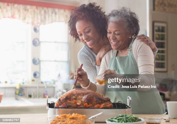 mother and daughter cooking together in kitchen - thanksgiving imagens e fotografias de stock