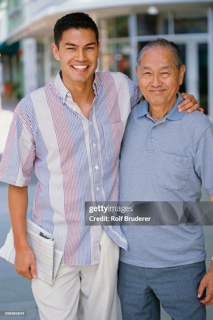 Father and son smiling on city street