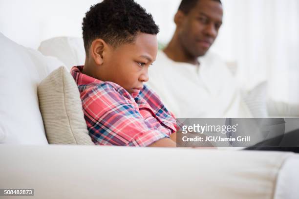 father and son arguing on sofa - angry boy stock pictures, royalty-free photos & images