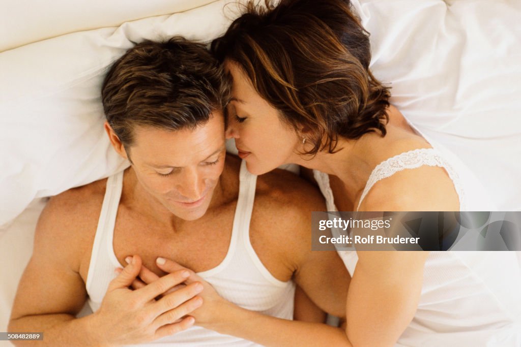 Couple hugging in bed