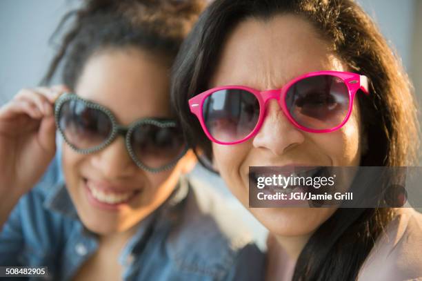 mother and daughter wearing novelty sunglasses - eltern sonnenbrille sonne lachen stock-fotos und bilder