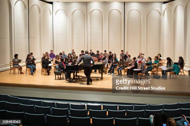 choir and conductor on stage - classical concert stock pictures, royalty-free photos & images