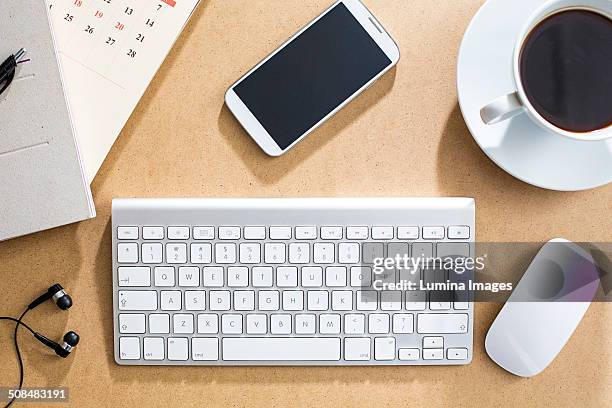 wireless keyboard, mouse and cell phone on table - computer mouse table stock-fotos und bilder