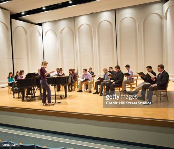 conductor directing choir on stage - choir stage stockfoto's en -beelden
