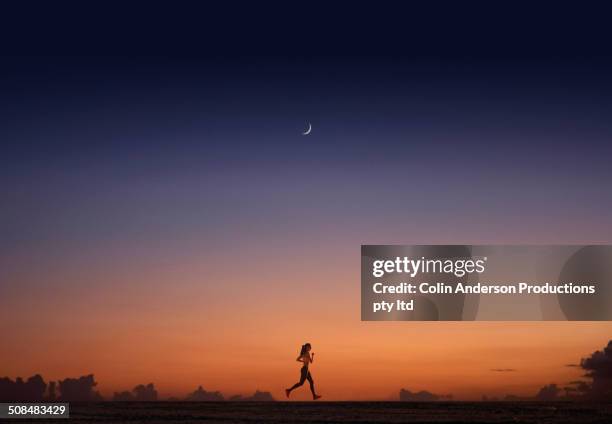 pacific islander woman jogging at sunset - nighttime routine stock pictures, royalty-free photos & images