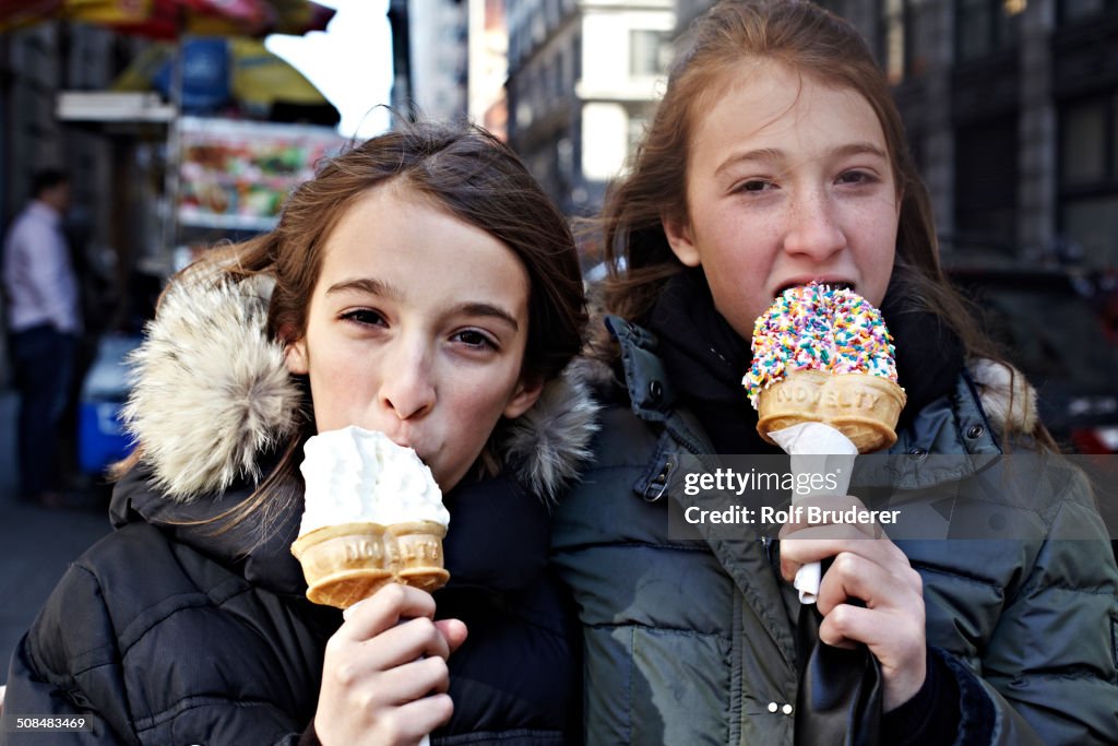 Girls eating ice cream on city street