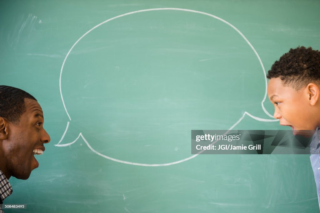 Teacher and student talking by empty speech bubble