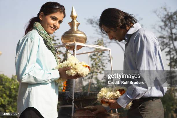 indian couple offering flowers to shrine - urn 個照片及圖片檔