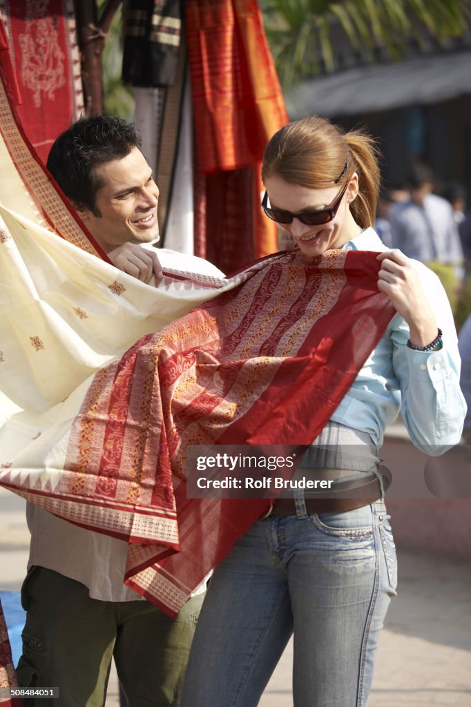 Couple admiring fabrics at outdoor market