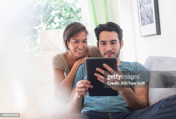 couple using digital tablet together - couple with ipad in home stock pictures, royalty-free photos & images