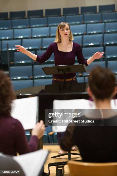conductor directing choir on stage - choir stage stockfoto's en -beelden
