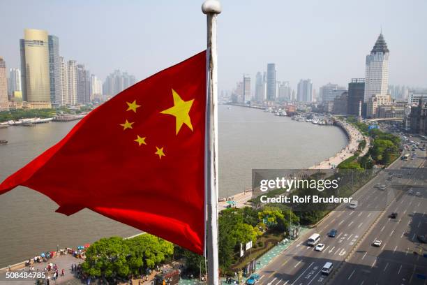 chinese flag overlooking cityscape, shanghai, china - chinese vlag stockfoto's en -beelden