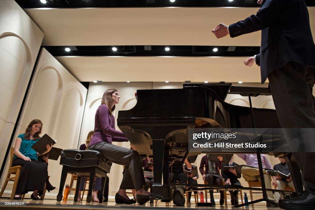 Conductor directing choir on stage