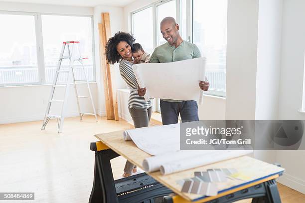 family examining blueprints in new home - family drawing 個照片及圖片檔