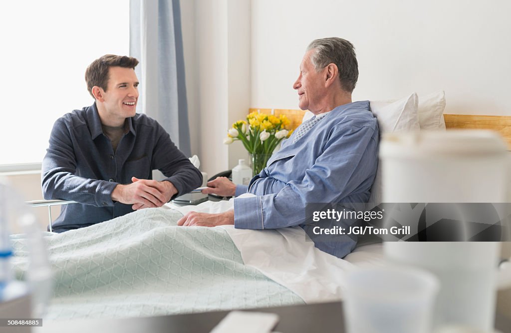 Caucasian son visiting father in hospital