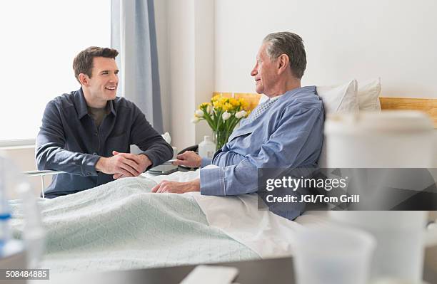 caucasian son visiting father in hospital - father and children volunteering stock pictures, royalty-free photos & images