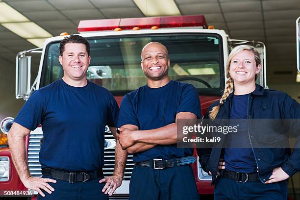 diverso equipo de bomberos en frente de camión de bomberos - emergency services fotografías e imágenes de stock