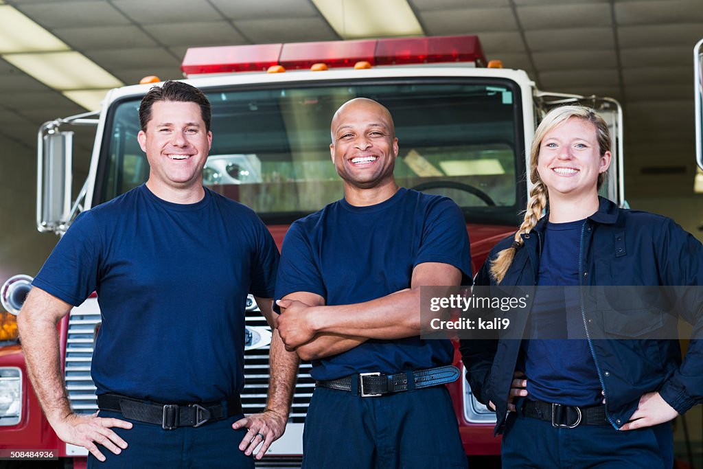 Diverse team of firefighters in front of fire engine