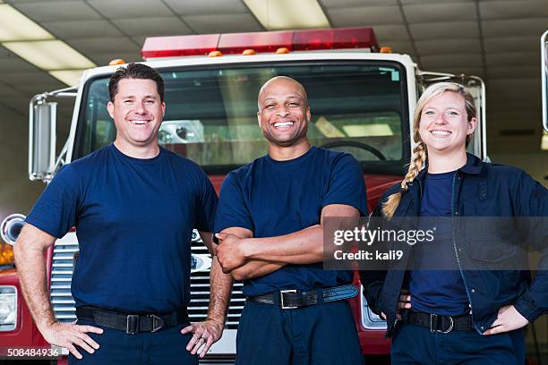diverse team of firefighters in front of fire engine - emergency services occupation stock pictures, royalty-free photos & images