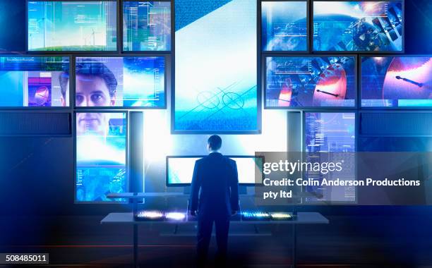 caucasian businessman using multiple screens at desk - tribeca film festival dumb the story of big brother magazine stockfoto's en -beelden